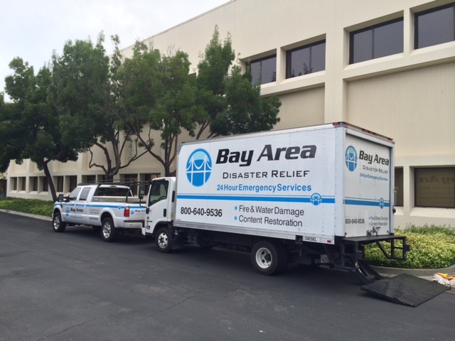 Truck and Box truck outside beige building